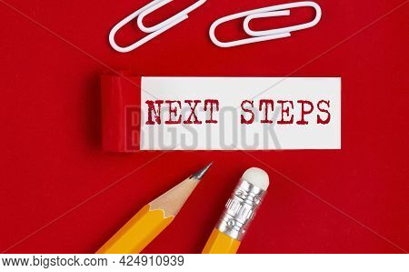 Next Steps Message Written Under Torn Red Paper With Pencils And Clips, Business