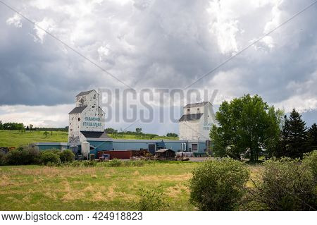 De Winton, Alberta - May 5, 2021: Old Grain Elevators Outside The Small Town Of De Winton, Alberta.