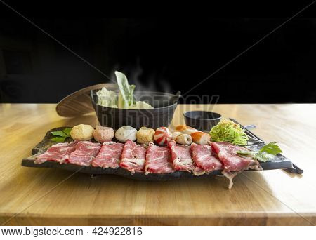 Set Of Shabu Fresh Raw Meat Beef Or Pork And Condition With Hot Soup In Black Bowl On Wood Table