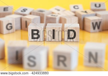 The Word Bid Is Written On A Wooden Cubes Structure. Blocks On A Bright Background. Financial Concep