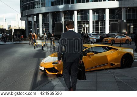 Business Center Of The City. Businessman In A Jacket And With A Briefcase Walking Down The Street Ne