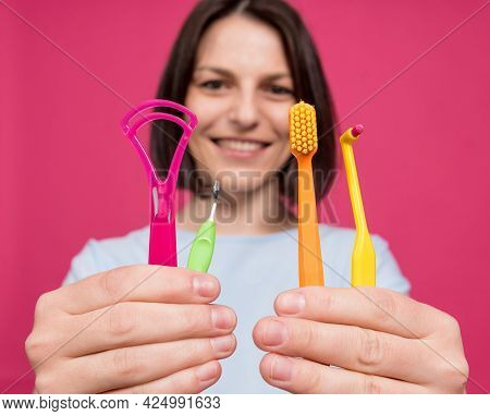 Beautiful Young Woman Uses An Oral Care Kit Consisting Of A Tongue Scraper, Single Tufted And Interd