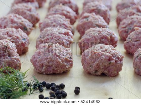 Raw Seasoned Meatballs On A Cutting Board