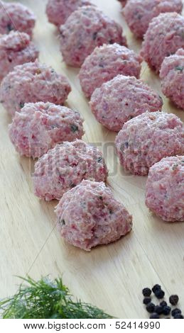 Raw Seasoned Meatballs On A Cutting Board