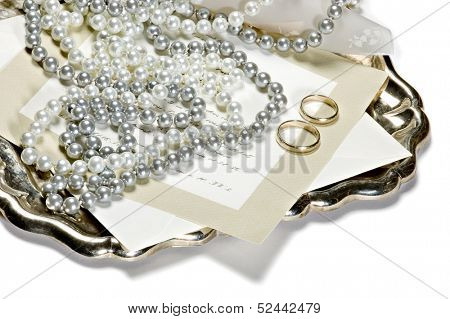 Two rings with chain on an antic silver tray with invitation card