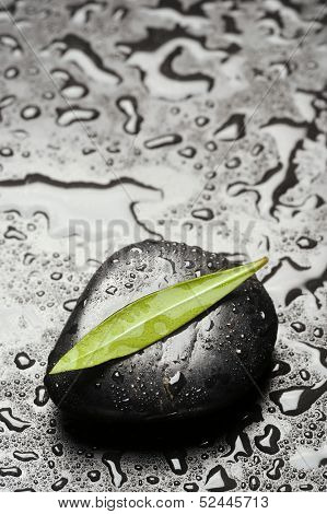 blak spa stones with leaf and water drops