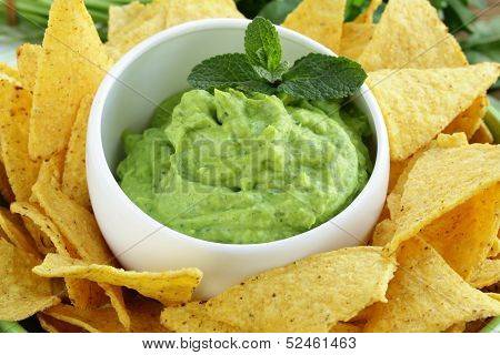 cup with guacamole and corn chips