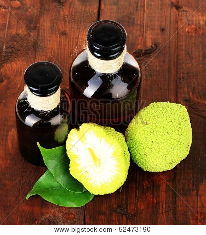 Osage Orange fruits (Maclura pomifera) and medicine bottles, on wooden background