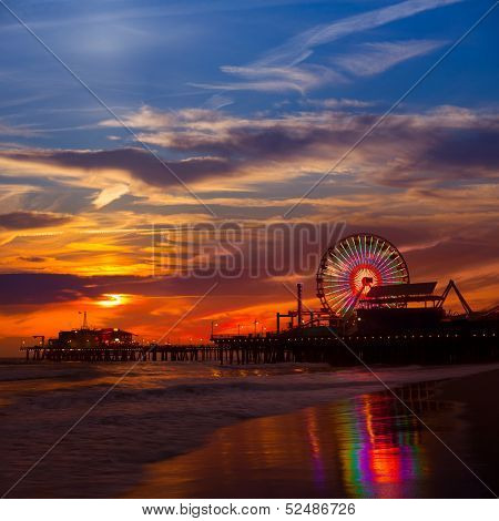 Santa Monica California sunset on Pier Ferrys wheel and reflection on beach wet sand  