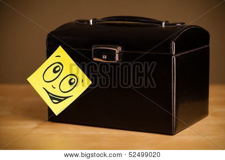 Drawn smiley face on a post-it note sticked on a jewelry box