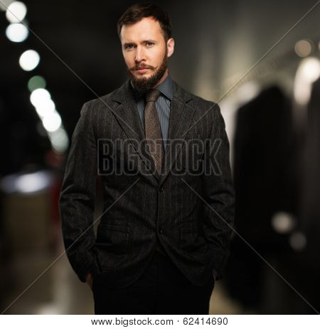 Handsome well-dressed man with beard in a clothing store