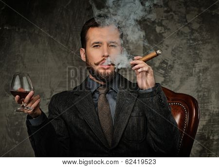 Handsome well-dressed with glass of beverage and cigar