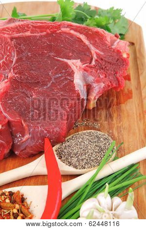 raw meat : fresh beef pork big rib piece with garlic and green stuff on wood isolated over white background