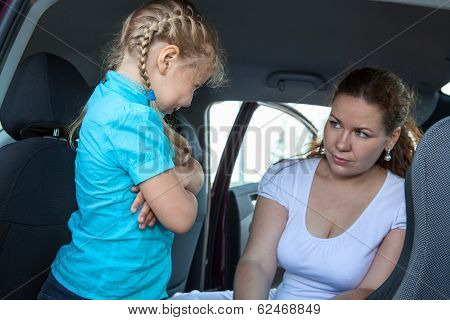 Resentful Child Refusing Get In Safety Car Seat Under Mother Severe Look