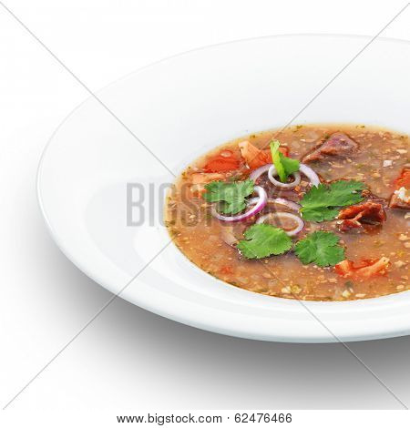 Traditional georgian hot tasty soup kharcho decorated with parsley. Isolated on white.
