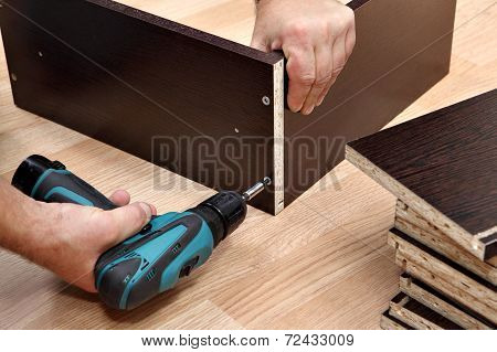 Furniture Assembly Using A Cordless Screwdriver, Close Up.