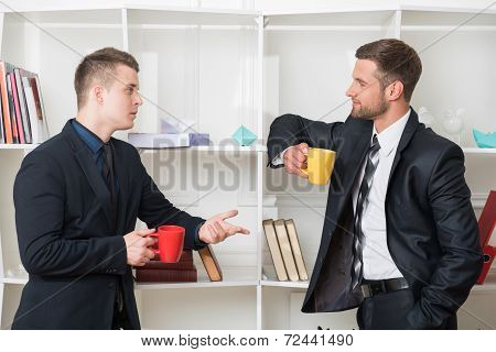 Portrait of two handsome businessmen in suits having a coffee-br