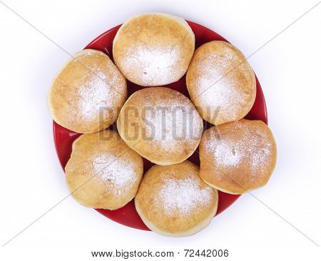 Donuts topped with powdered sugar on a white