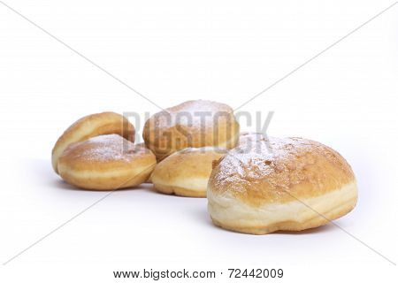 Donuts topped with powdered sugar on a white