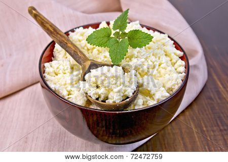 Curd In Wooden Bowl With Spoon And Mint On Board