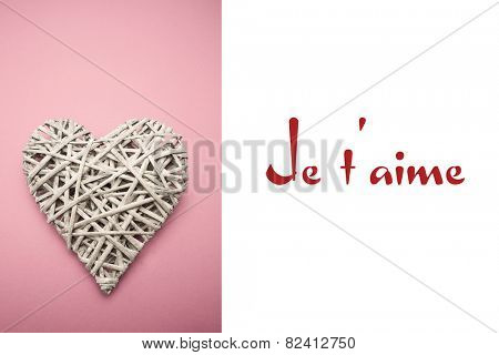 Wicker heart ornament against valentines love hearts