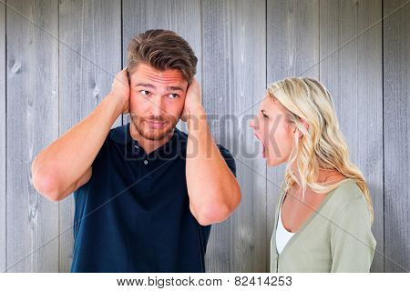 Man not listening to his shouting girlfriend against wooden planks