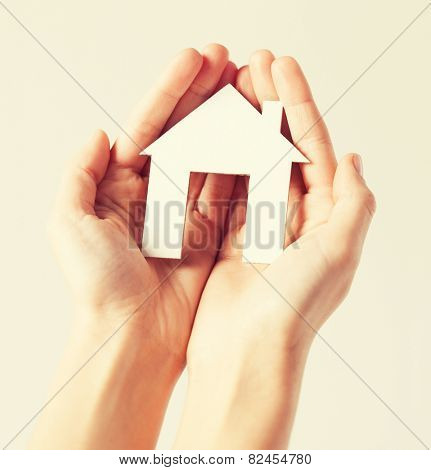 pisture of woman hands holding paper house