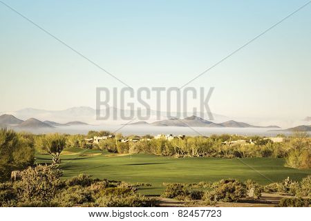 Scottsdale, Phoenix area golf course with dramatic unusual low lying fog in below mountain peaks in distance