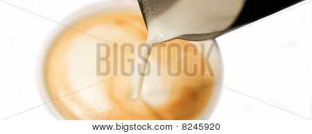 Barista wlewając mleko do kawy