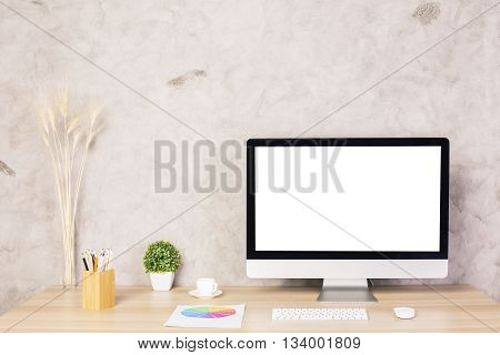 Creative designer desktop with blank white computer monitor keyboard coffee cup plant other decorative items and colorful diagram. Mock up