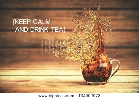 Keep calm and drink tea concept with splashing cup of tea on dark wooden background. 3D Rendering