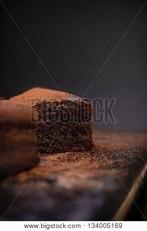 A close up slice of flourless chocolate cake on a dark background. Dark food photography. Free text space layout.