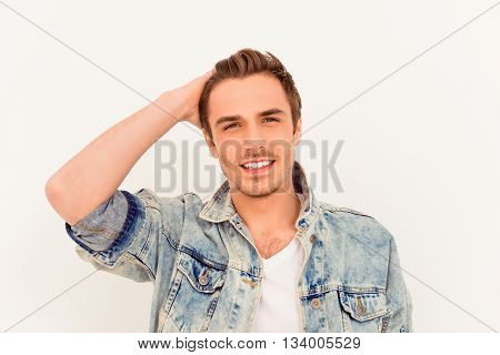 Attractive man in jeans jacket touching his hair