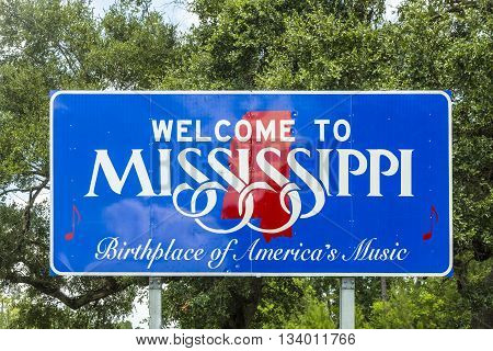 Red white and blue sign to welcome travelers to Mississippi - Birthplace of America's Music