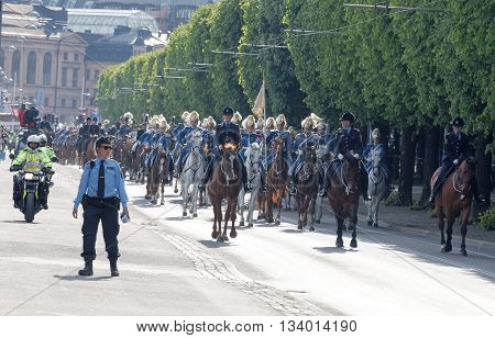 STOCKHOLM - JUN 06 2016: The Royal guards on the horse back and the police protecting the swedish royal family on their way to celebrate the swedish national day