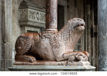 The columns of the Cremona's cathedral narthex stand on two lions in Verona marble. The right one is holding a bear which in turn is biting a bird's neck.