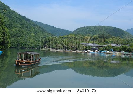 ARASHIYAMA, JAPAN - MAY 22, 2016: A pontoon boat crosses the Katsura River.