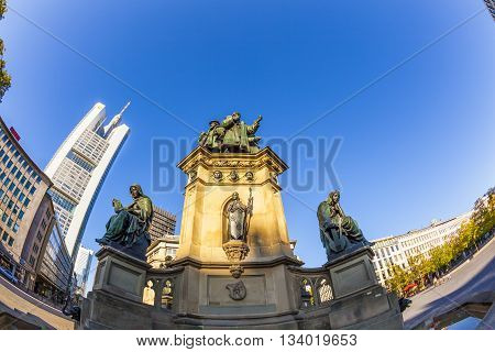 FRANKFURT, GERMANY - JUNE 9, 2012: statue of Johannes Gutenberg inventor of book printing with skyscrapers Frankfurt Germany