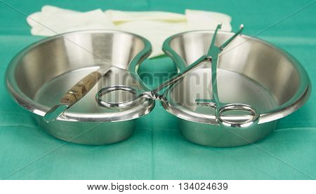 Surgical Clamp And Knife Placed On Kidney Shape Bowl