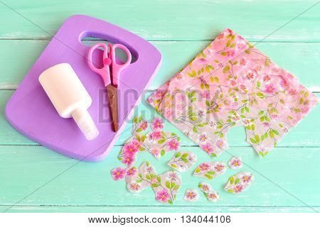 Painted wooden kitchen board. Wooden handmade chopping board kitchen decor. Paper napkin, cut floral fragments, scissors. Decoration items. Set for decoupage, recycled crafts