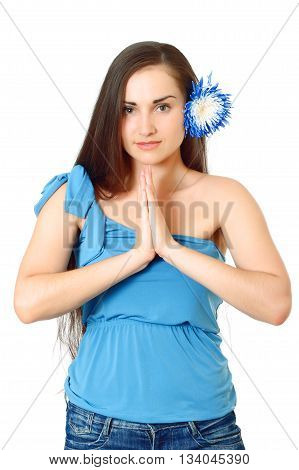 nice-looking attractive woman with flower in long dark hair in blue t-shirt stands folding arms on white background, isolated