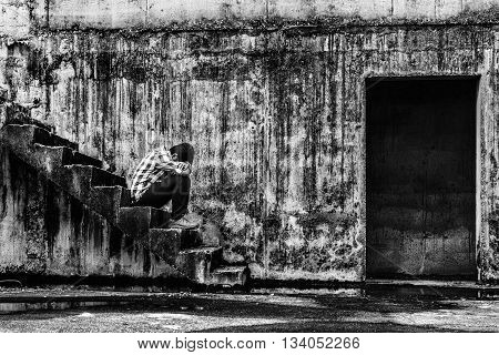 depressed teenager sitting on stair in creepy abandoned building darkness concept