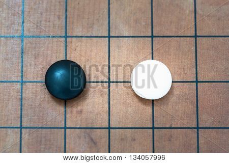 top view closeup white stone approach to black stone on go game board traditional chinese strategy board game sport hobby and recreation