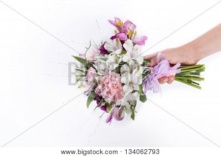Hand holding a pink summer bouquet from gillyflowers and alstroemeria