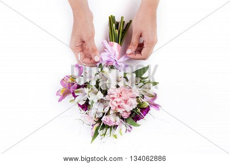Making a ribbon on pink bouquet from gillyflowers and alstroemeria