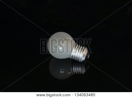 Turbid light bulb reflects from the dark surface