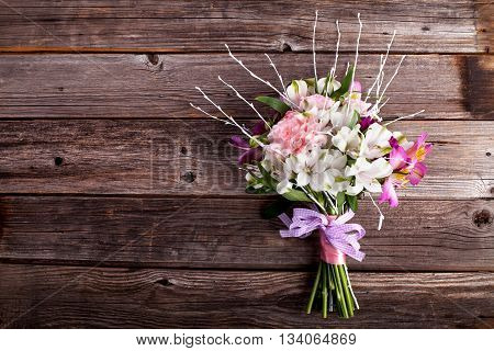 Rustic bouquet from gillyflowers and white alstroemeria on old rustic wooden background