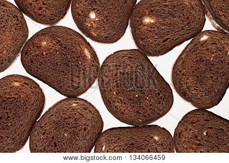Slices of black rye bread on a white background. Food background. Pattern.