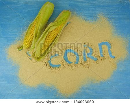 corn flour and corn on the cob on a wooden table