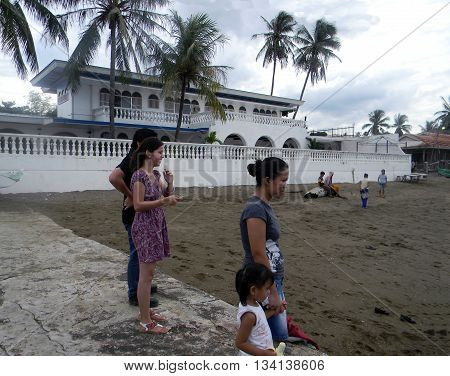 CEBU CITY, CEBU / PHILIPPINES - JULY 30, 2011: People enjoy the beach in front of a large beachfront mansion in Cebu.